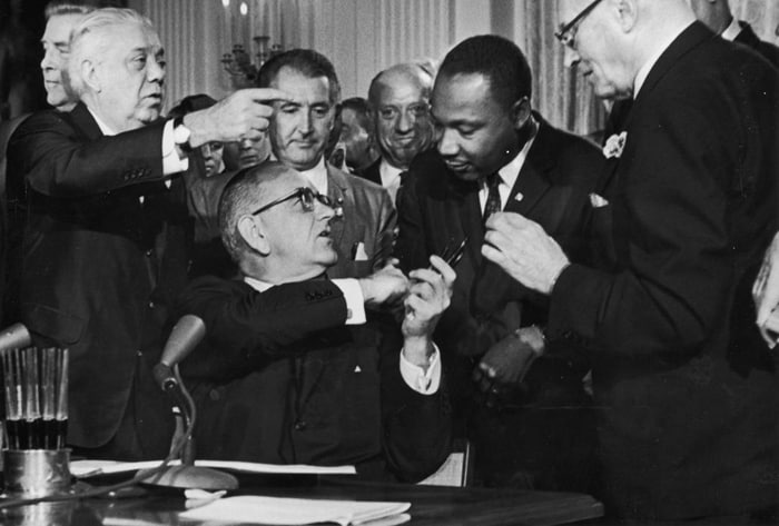 مارتین لوتر کینگ و پرزیدنت «لینسون جانسون» در حال امضای قانون «حقوق مدنی» در واشنگتن دی سی
